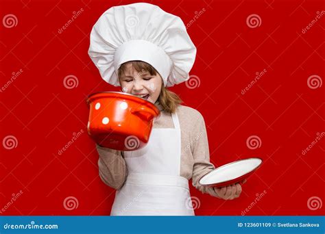 Happy Little Girl In Chef Uniform Holds Saucepan Isolated On Red Kid
