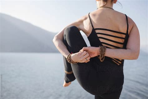 Woman Doing Yoga Practice By The Lake By Stocksy Contributor Michela Ravasio Stocksy