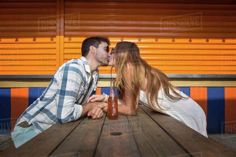 Couple Sitting Face To Face At Picnic Table Kissing Coney Island Brooklyn New York Usa