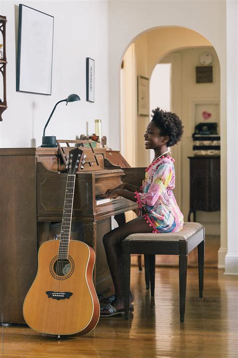 Smiling Black Girl Playing Piano At Home By Stocksy Contributor