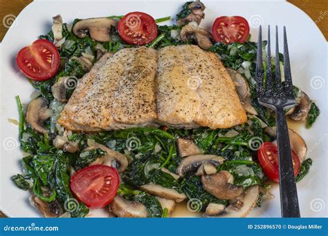 Season Baked Salmon With Sauteed Spinach And Mushrooms Stock Photo