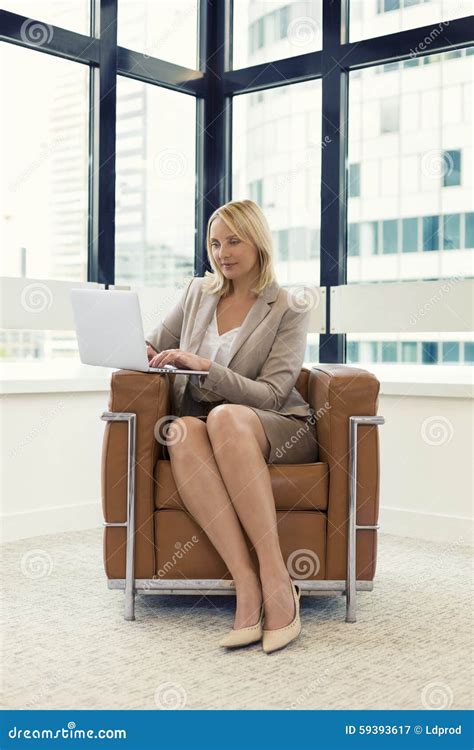 Cheerful Business Woman Sitting In A Chair Working On Laptop In Modern Office Stock Image