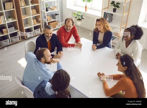 Team Of Happy Diverse Employees And Coworkers Sitting Around Office