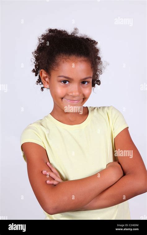 Studio Portrait Of A Smiling African American Girl With Arms Folded
