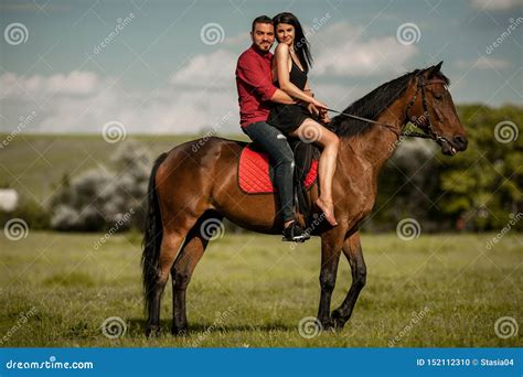La Giovane Coppia Sta Montando Un Cavallo Marrone Fotografia Stock