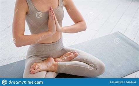 motion past lady yoga practitioner in new beige tracksuit sitting in lotus position with namaste
