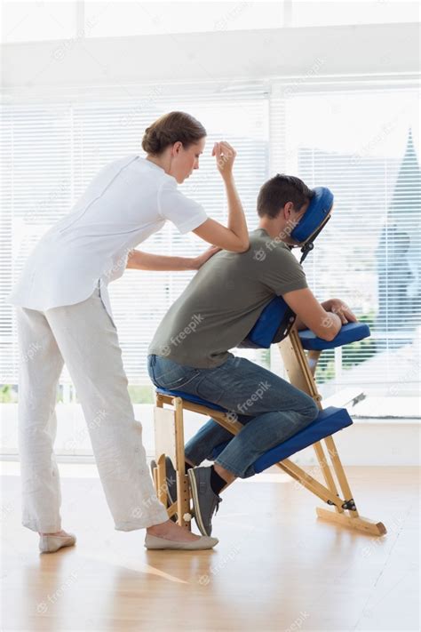 premium photo female therapist giving back massage to man