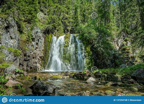 Waterfall Flushing Down A Green Moss Covered Rock Wall Stock Photo