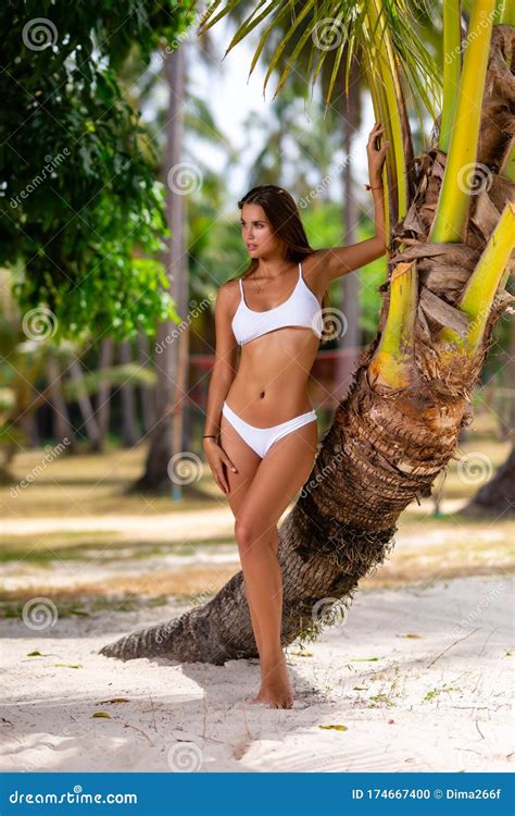 Beautiful Girl In White Bikini Posing At The Tropical Beach Stock Photo