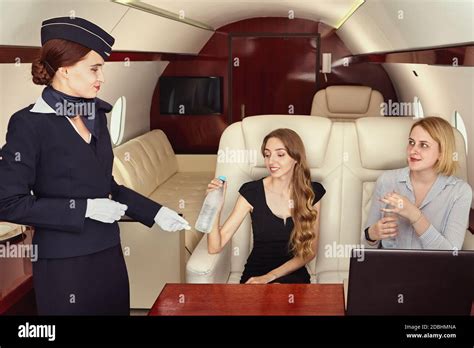 Cabin crew serves business class passengers inside the plane. Air