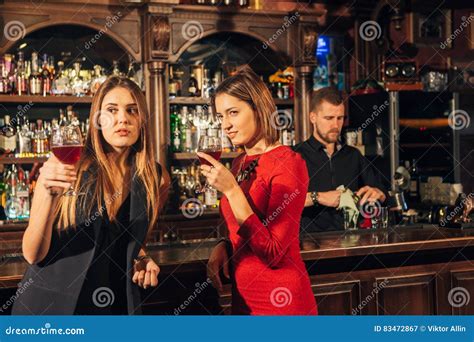 Two Female Friends Are In The Bar For A Drink And Talk The Woman With