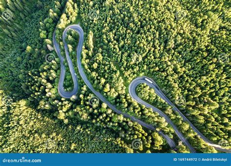 Aerial View Of Winding Road In High Mountain Pass Trough Dense Green