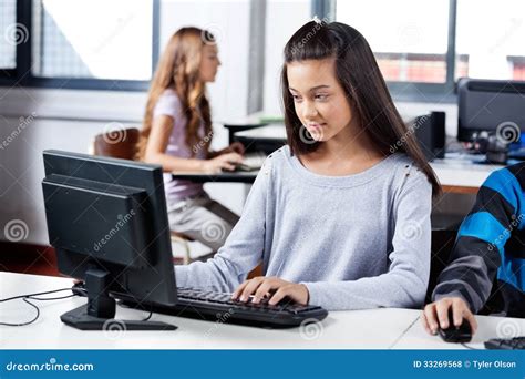 Girl Using Computer With Friends In Classroom Royalty Free Stock Photos