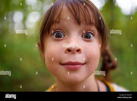 Portrait Of A Wide Eyed Girl Standing Outdoors United States Stock