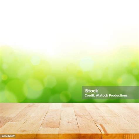 Wood Table Top On Bokeh Abstract Green Background Stock Photo