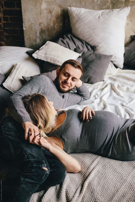 Happy Pregnant Couple Posing On Bed By Stocksy Contributor Andrey