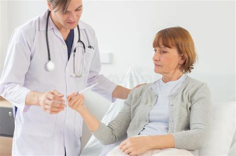 The Doctor Is Examining The Patient In The Hospital Caucasian Doctor Wearing Gown And Listening