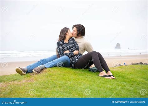 Young Biracial Couple Kissing On Grass Hill Next To Ocean Stock Image Image Of Coast Biracial