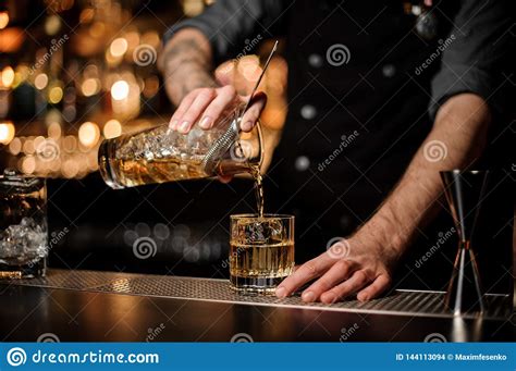 Bartender Pouring An Alcohol From The Measuring Glass Cup Through The