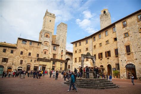 towers and medieval well on piazza della cisterna in san gimignano in tuscany in italy editorial