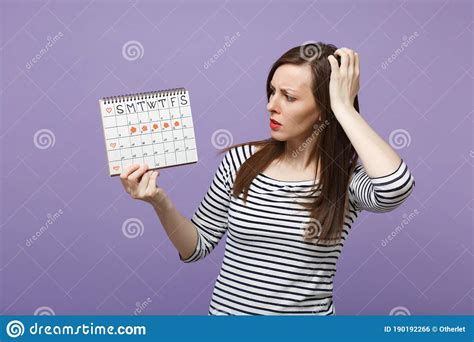 Young Woman Holding In Hand Female Periods Calendar For Checking
