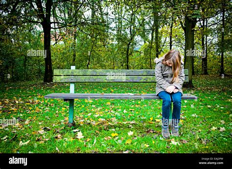 Lone Girl Sitting On A Bench Stock Photo Alamy