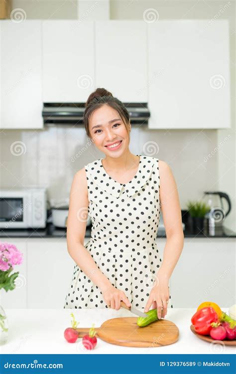 Portrait Of Young Asian Beautiful Woman Cooking In Kitchen Stock Image