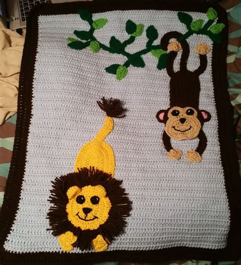There Is A Crocheted Blanket With Monkeys And A Monkey Hanging From It