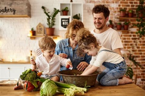 Familia Feliz Con Sus Hijos Cocinando En La Cocina Foto De Archivo