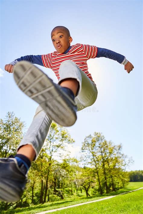 African Boy Is Making A Jump In The Park Stock Photo Image Of