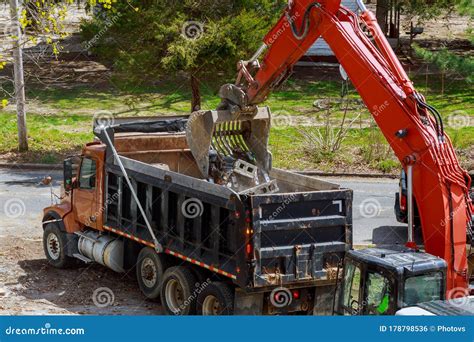 Excavator Picks Up Construction Waste For Loading Onto A Truck Stock Photo Image Of Debris