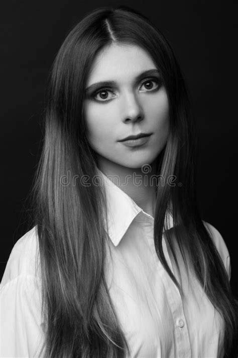 Black And White Portrait Of A Beautiful Woman In A White Shirt On A Black Background Stock Image