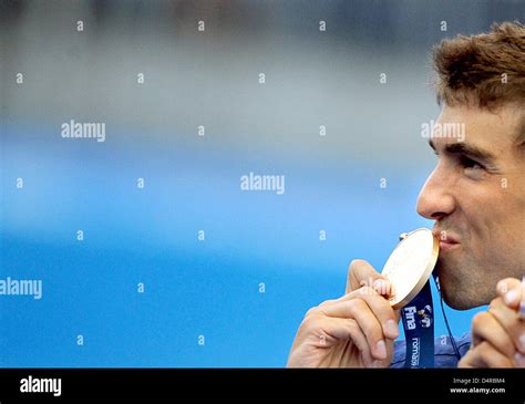 us swimmer michael phelps kisses his gold medal after his victory at the mens 100m butterfly
