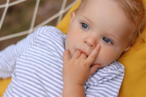 Premium Photo Closeup Portrait Of Calm Cute Curious Blonde Infant Girl Wearing Striped Shirt