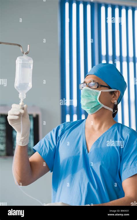 Surgeon Checking A Saline Drip Stock Photo Alamy