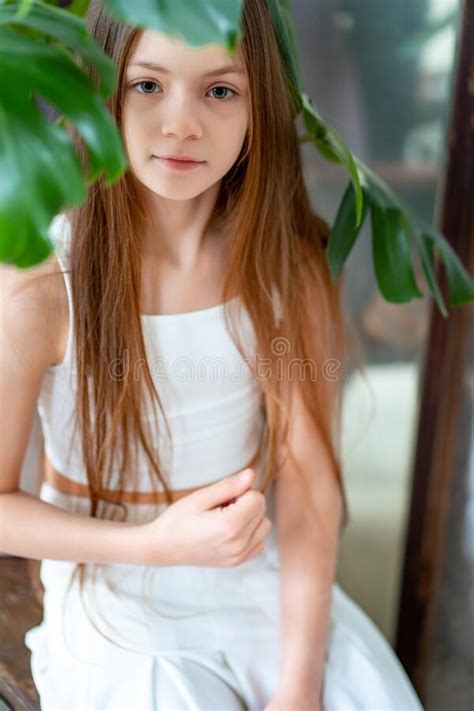 Beautiful Teenage Girl With Long Hair In White Clothes On The Couch