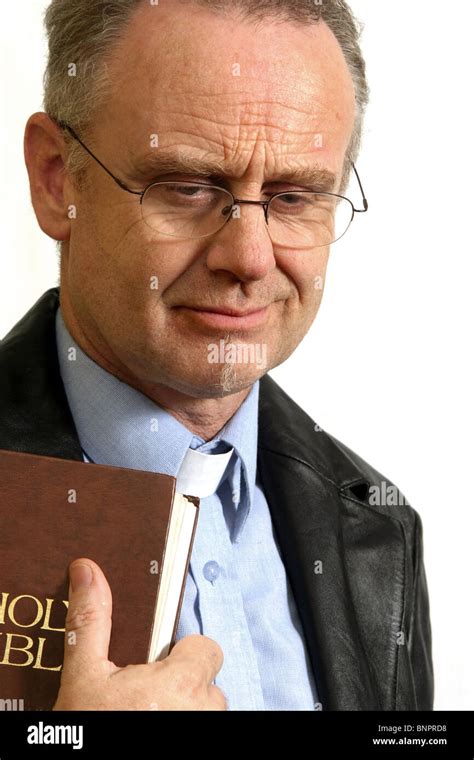 Trendy Mature Vicar Holding His Bible Stock Photo Alamy