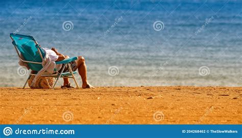 Enjoying The Sun Sea And Sand While Relaxing On A Sunchair At A Quiet