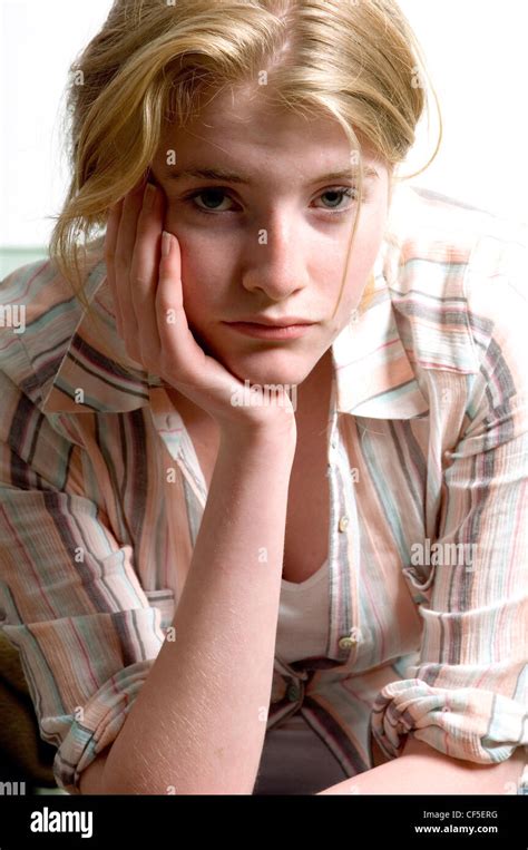 Female Sitting On A Sofa Leaning Her Head On Her Hand And Resting Her