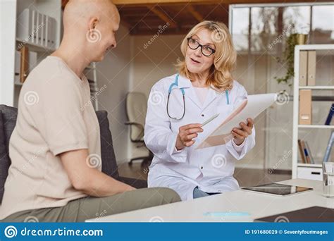 Mature Female Doctor Talking To Patient In Clinic Stock Image Image