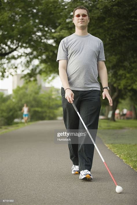 Blind Man Walking On A Walkway With A Blind Persons Cane High Res Stock