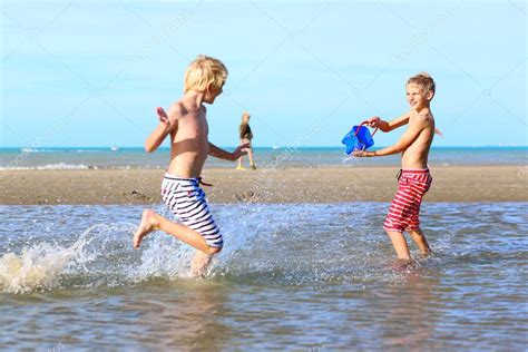 Two Active Boys Playing On The Beach Stock Photo By ©cromary 70842471