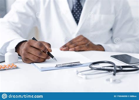 Close Up Of African Doctor Prescribing Pills To Patient Stock Photo