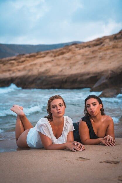 premium photo caucasian lesbian couple posing on the beach in summer