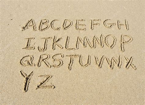 alphabet letters handwritten  sand  beach stock photo spon