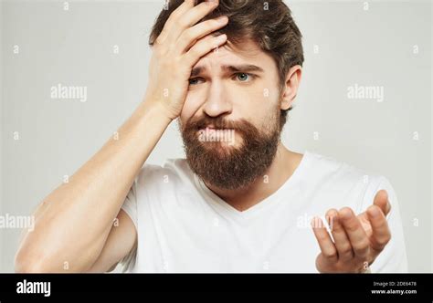 Bearded Man Holding His Head Emotions Gestures With His Hands White T