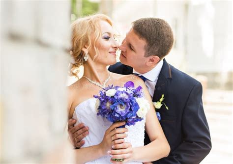 Handsome Brunette Groom Kissing Beautiful Bride In Wedding Dress Stock