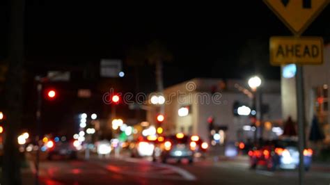 Defocused Evening Street Lights Of City Cars On Rainy Night Road In