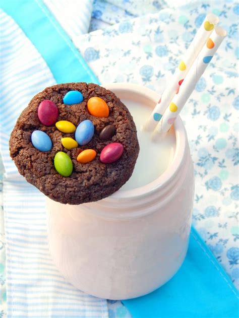 A Chocolate Cookie With M And M Candies In It And Two Straws Sticking Out Of The Top
