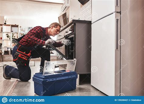 Whats Up With Oven Full Length Of Repairman Examining Oven Stock Image
